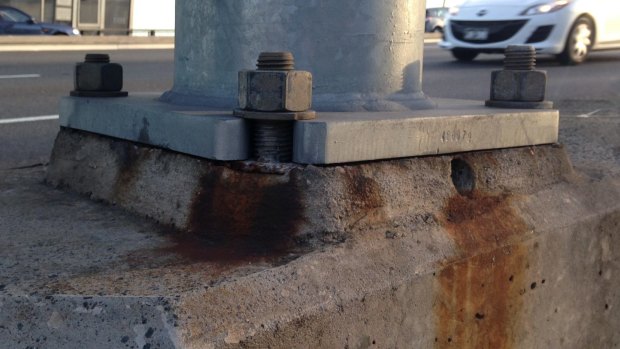 Signs of rust and discoloration at the bases of the bridge light towers.