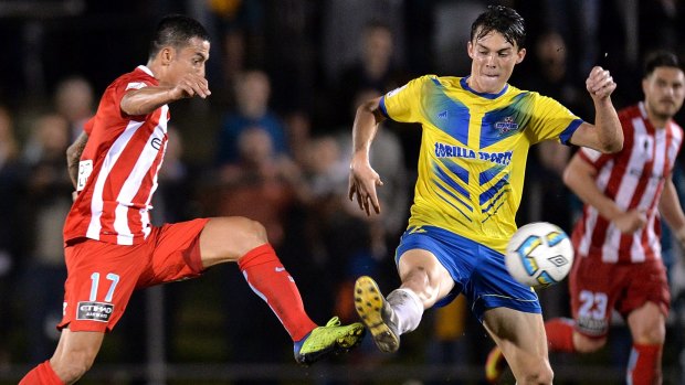 Welcome back: Tim Cahill and Jake Marshall battle for possession.