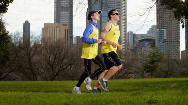 Adam Koops, who is blind, trains on Sundays with Achilles Running Club volunteer Amelia Griffith around the Tan running track around Melbourne's Royal Botanic Gardens.
