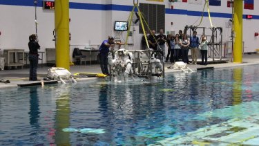 Astronauts are lowered into a pool at NASA's Neutral Buoyancy Lab.