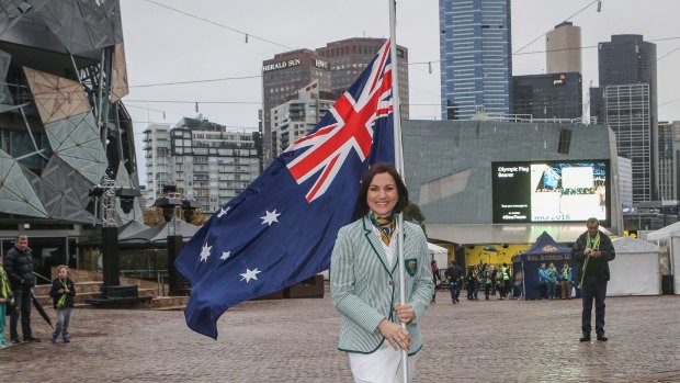 Anna Meares gets some practice for Rio, carrying the flag through Federation Square in Melbourne.