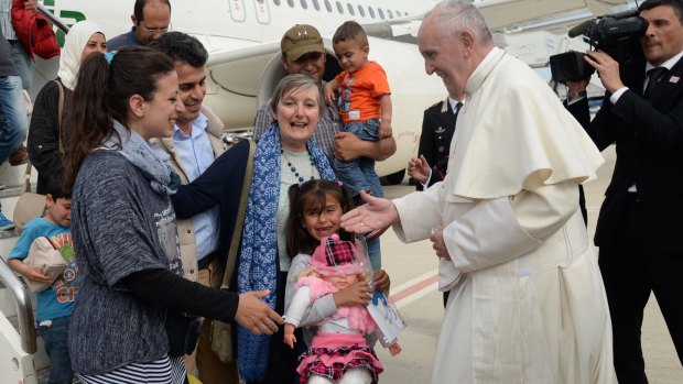 Pope Francis greets a group of Syrian refugees.