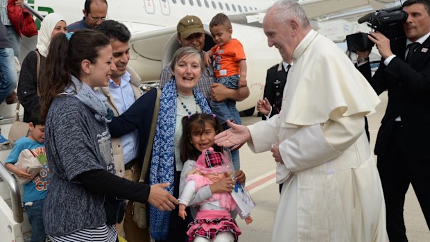 Pope Francis greets a group of Syrian refugees.