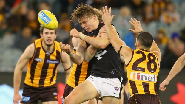 Patrick Cripps of the Blues handballs during the round 23 match against Hawthorn.