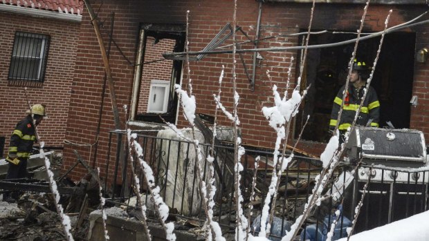 Firefighters at the scene of a house fire in the Midwood neighbourhood of Brooklyn that killed seven children on Saturday. 