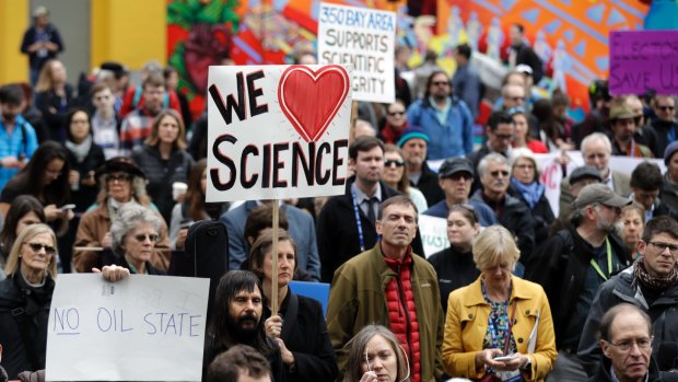 People hold signs as they listen to a group of scientists speak during a rally in conjunction with the American Geophysical Union's meeting in December.