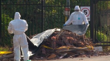 An emergency HAZMAT crew respond to dumped building material found on a suburban back street on Saturday.