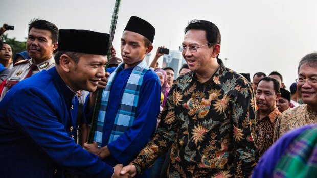 Ahok, right, greets people in Jakarta in 2014. A Christian and ethnic Chinese, he became governor after his predecessor and political ally Joko Widodo was elected president of Indonesia.