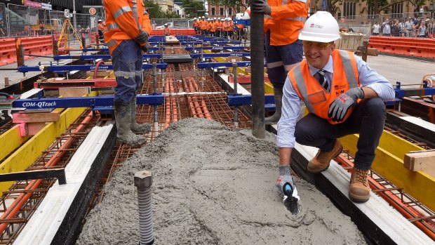 NSW Minister for Transport Andrew Constance witnessing the first track being cemented in place. 