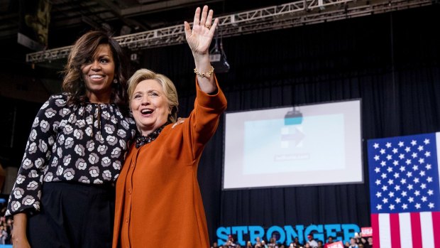 First lady Michelle Obama and Democratic presidential candidate Hillary Clinton stand on stage after speaking at a campaign rally at Wake Forest University in Winston-Salem, NC.