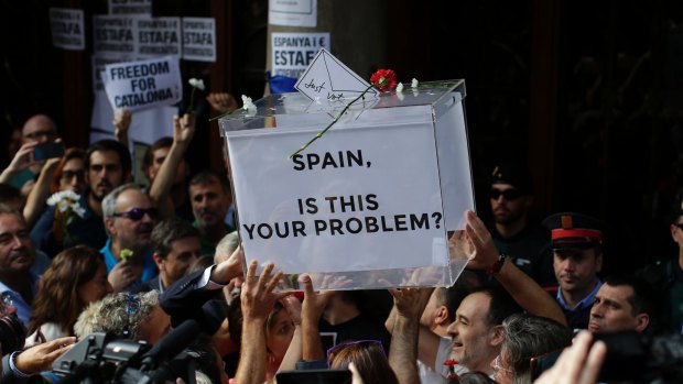 Protesters hold up a fake ballot box as they gather outside Catalonia's department of economic affairs in Barcelona on Wednesday.