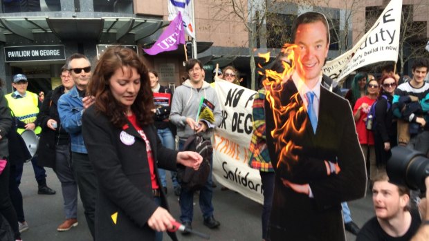 Chloe Rafferty, NSW education officer for the National Union of Students, lights an effigy of Education Minister Christopher Pyne.
