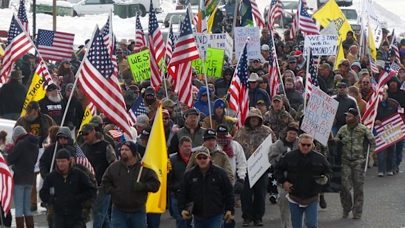 Protesters march in support of an Oregon ranching family facing jail time for arson in Burns, Oregon, ahead of the militant takeover of a federal building. 
