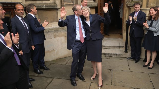 Theresa May and her husband Phillip May wave before she makes a statement after Andrea Leadsom pulled out of the contest on Monday.