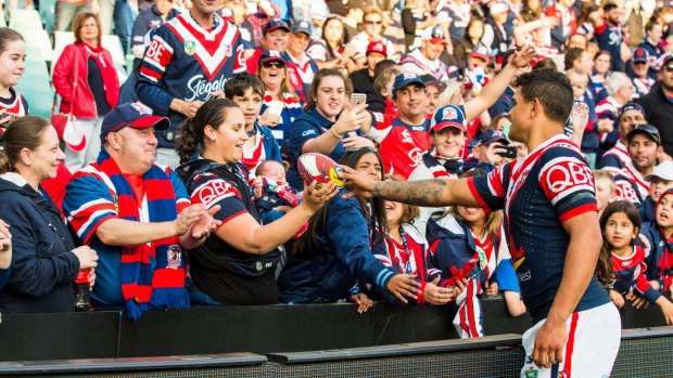 Last man: Latrell Mitchell giving a Roosters football to a new mum for her baby.