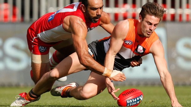 Stephen Coniglio of the Giants and Adam Goodes of the Swans compete for the ball.
