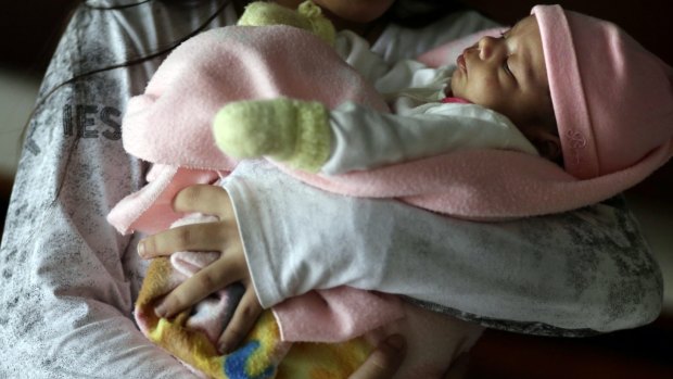 A teen girl holds her one-month-old baby at a shelter for troubled children in Ciudad del Este, Paraguay in May. 