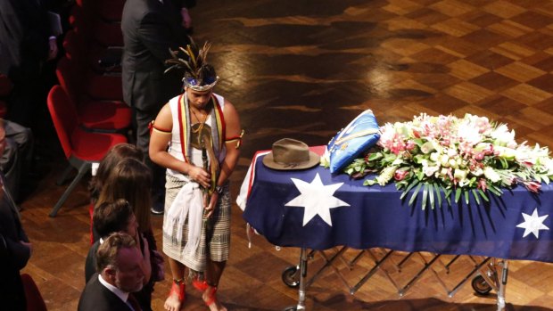 An East Timorese ceremonial dancer alongside Uren's decorated casket at the Town Hall.