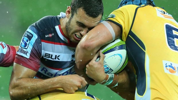 Close and personal: Jack Debreczeni is tackled by Brumby Scott Fardy. The Rebels have made gains but Australia's finals hopes are carried by the men from ACT.