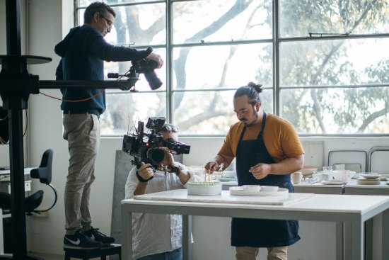 Adam Liaw (right) plates up a dish ready for William Meppem (left) to shoot in the Good Food Kitchen studio.