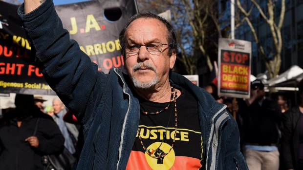 A protester marches on NSW Parliament House over Eric Whittaker's death.