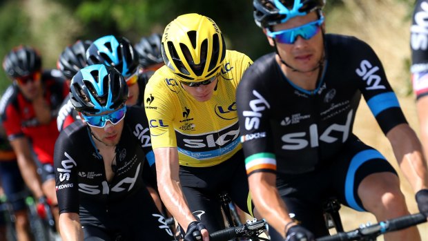 Protective custody: Chris Froome is shielded in the peloton by Sky teammates Nicolas Rocheand Leopold Konig.