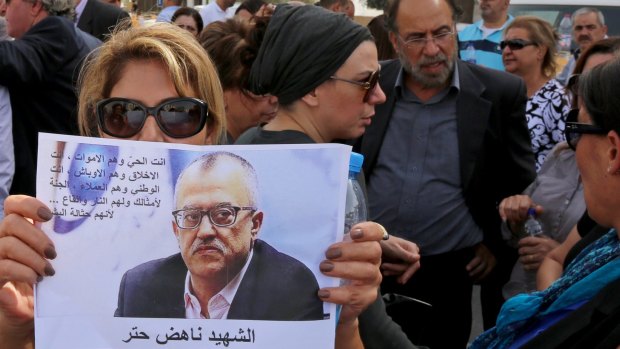 Relatives and friends of prominent Jordanian writer Nahed Hattar hold pictures of him and chant slogans against the government during a sit-in in the town of Al-Fuheis near Amman on Sunday.