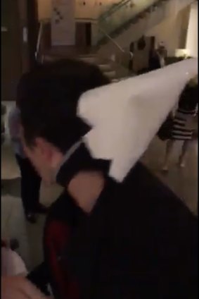 A man wearing a KKK hood is ejected from the venue.