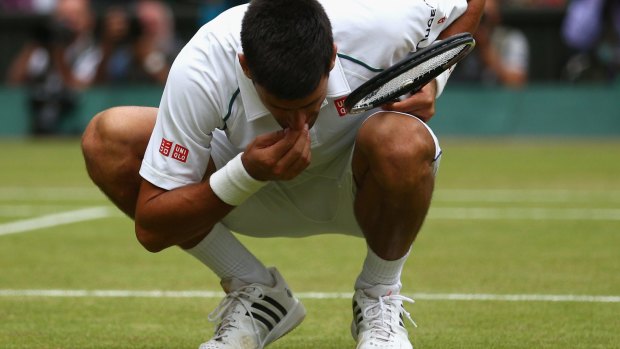 Sweet taste of success: Djokovic eats the centre court grass after winning Wimbledon.