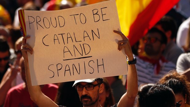 A man holds up a sign during a march in downtown Barcelona, Spain, to protest the moves for Catalan independence.