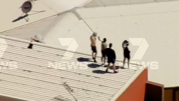 Youths take to a roof at the centre.