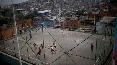 Youths play on an unforgiving pitch in a Rio favela. 