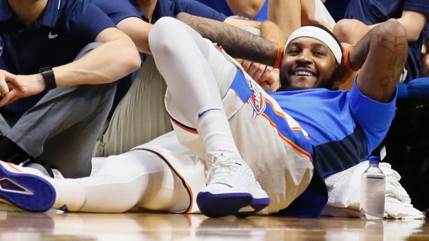 Oklahoma City Thunder forward Carmelo Anthony smiles as he watches the fourth quarter of an NBA pre-season basketball game.