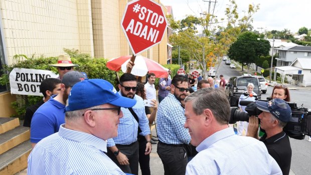 Attorney-General Georg Brandis and Queensland LNP leader Tim Nicholls with anti-Adani coal mine protesters during the recent state elections.