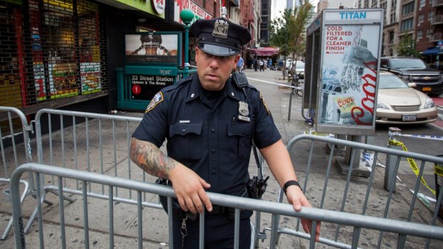 A New York City Police Department officer places barricades near the site of a bombing in 2016.