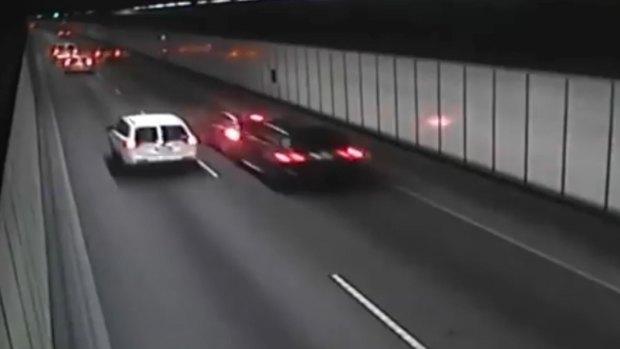 The dramatic moment when a black BMW rammed a Holden Astra, causing it to smash into the M5 tunnel wall. 