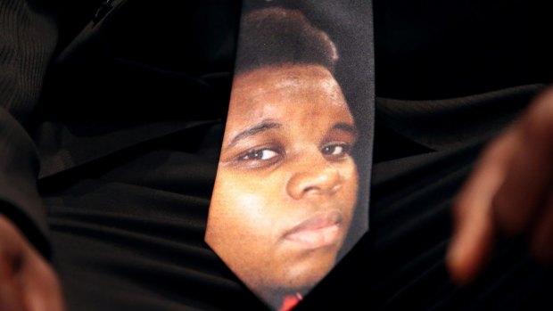 A man wears a tie decorated with a picture of Michael Brown during Brown's funeral at Friendly Temple Missionary Baptist Church in St Louis in August 2014.
