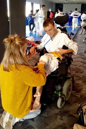 Canberra United defender Hannah Brewer helps her brother Tom get ready for judo.