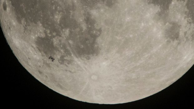 The International Space Station, with a crew of six onboard, is seen in silhouette as it transits the Moon on Saturday.
