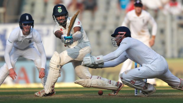 India's Cheteshwar Pujara finds runs on the leg side on an unhappy second day for England in Mumbai.