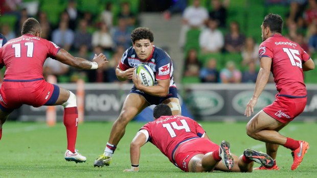 Sione Tuipulotu drives the ball forward on debut against the Reds