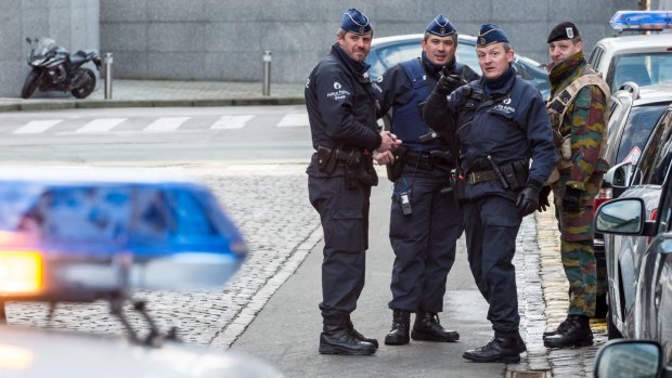 Policemen and a security officer stand outside a European Parliament building in Brussels on Monday.