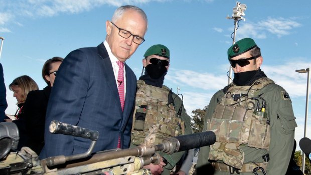 Prime Minister Malcolm Turnbull examines some military hardware during a media conference at Holsworthy Barracks on Monday.