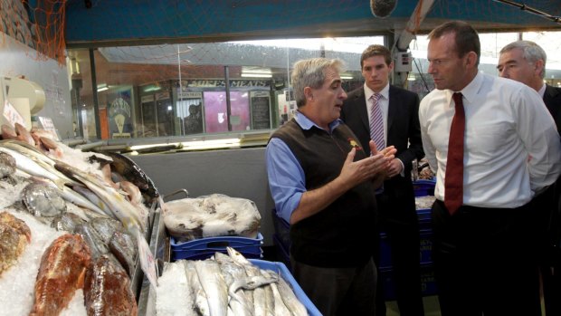 Then-opposition leader Tony Abbott speaks with John Fragopoulos during a visit to the Belconnen Fresh Food Markets in 2011.
