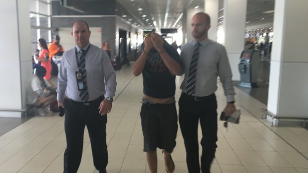 Christopher Lavery is escorted through Cairns Airport by Victoria Police homicide squad detectives in April last year.