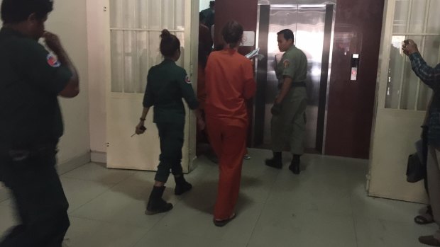 Australian nurse and surrogacy broker Tammy Davis-Charles, in orange, arrives in court in Phnom Penh on May 18.