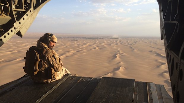 An Emirati gunner watches for enemy fire from the rear gate of a United Arab Emirates Chinook military helicopter flying over Yemen. 