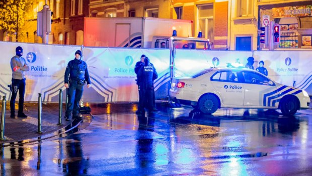 Belgian police guard a street in Brussels where arrests linked to the Paris attacks were made.