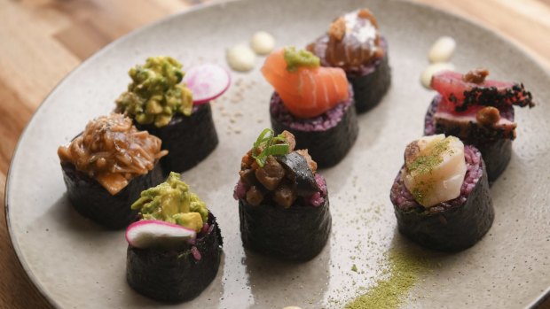 Purple rice nori rolls are sliced and garnished like nigiri-sushi hybrids.