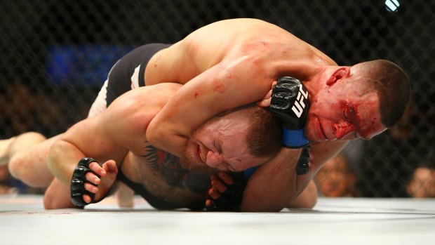 Nate Diaz applies a choke hold to win by submission against Conor McGregor.